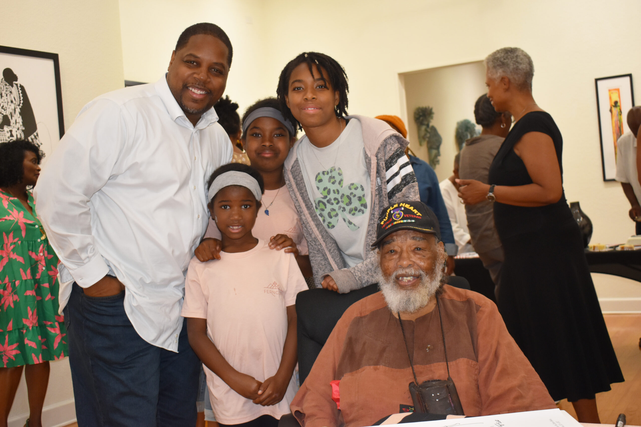 Dr. Chris Jones and his daughters pose with artist Frank Frazier