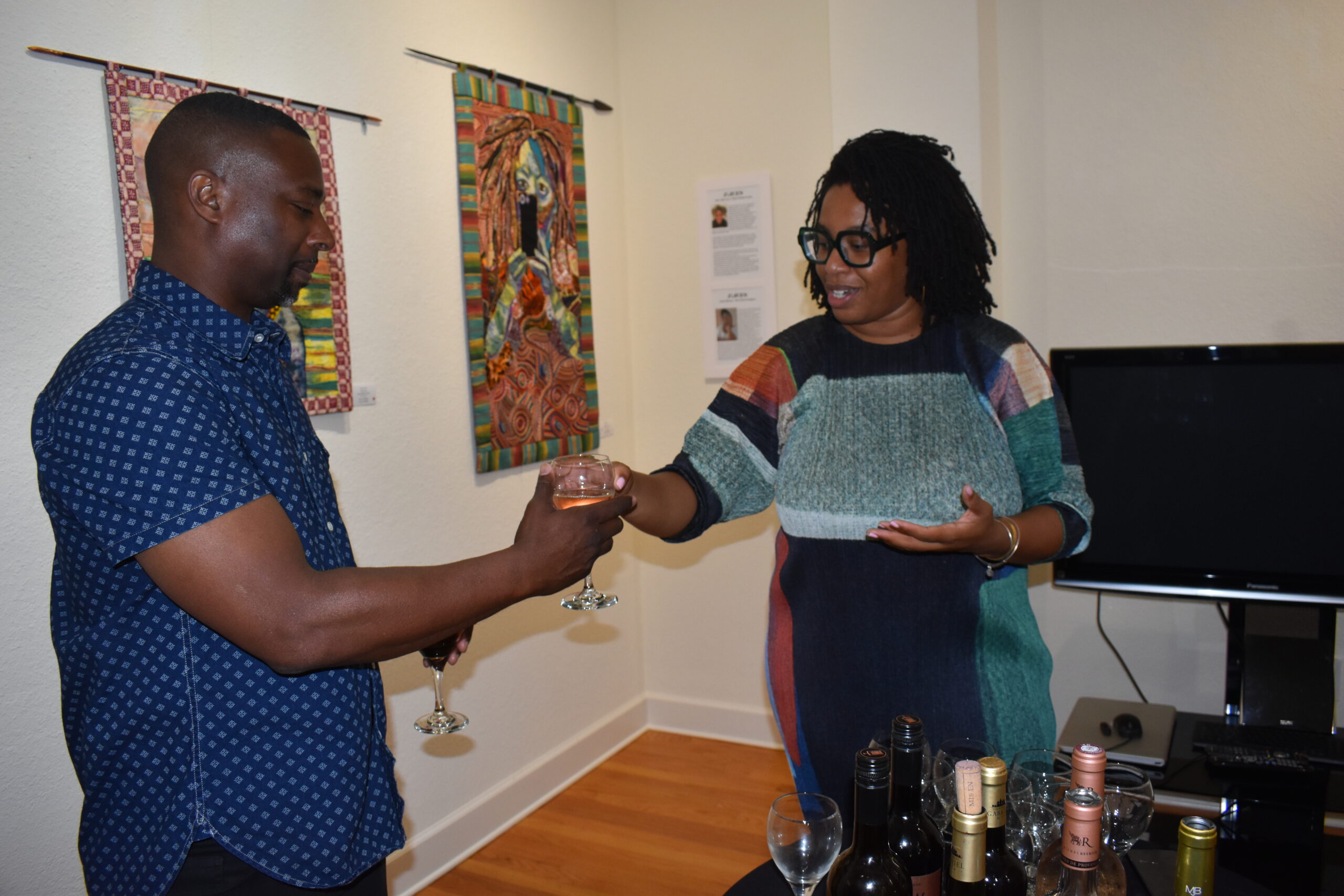 Kara Wilkins, owner Flyght Black Wine assists Anthony Tidwell with a glass of Sun Goddess wine.